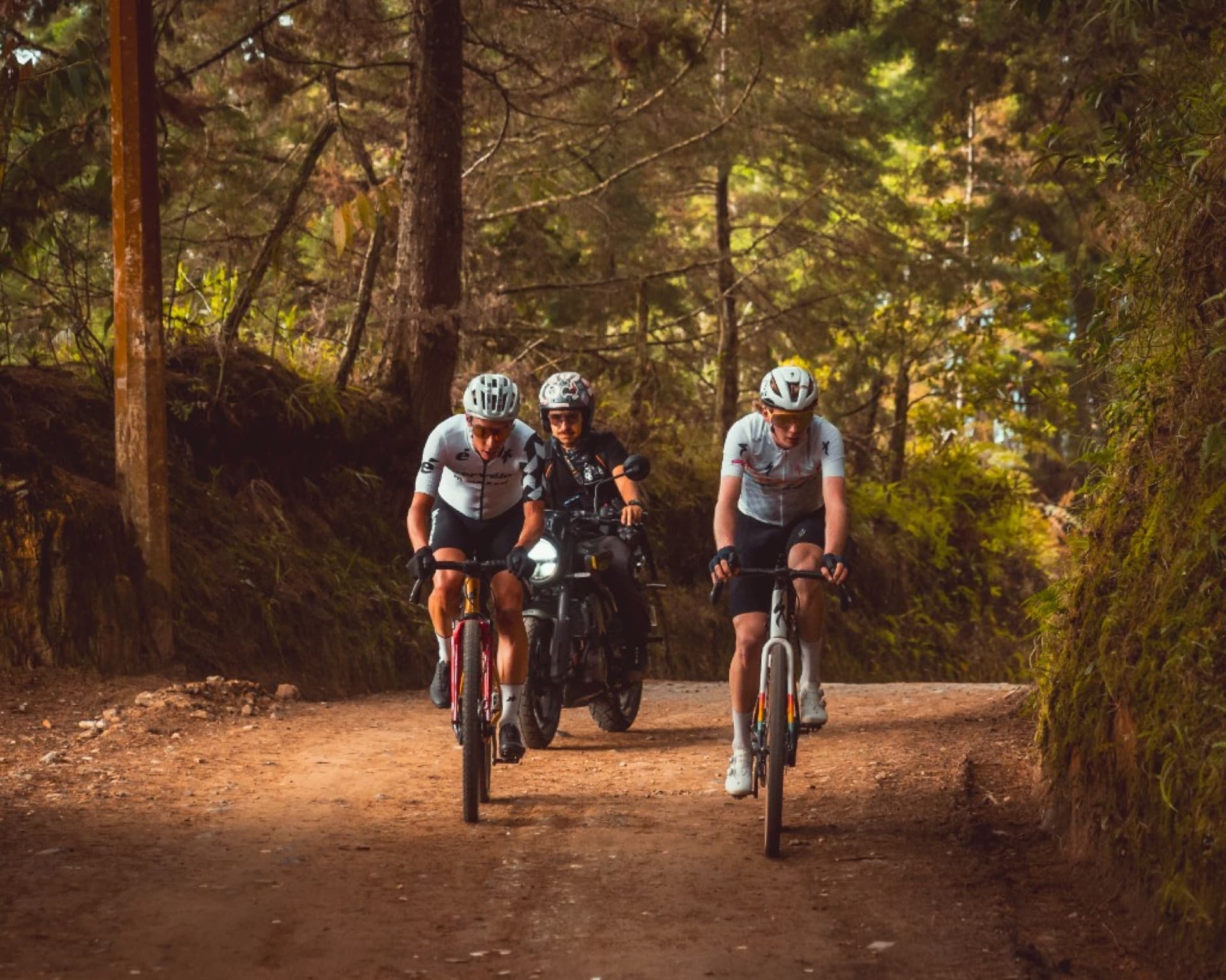 Ciclistas en trail de montaña seguidos por moto de apoyo